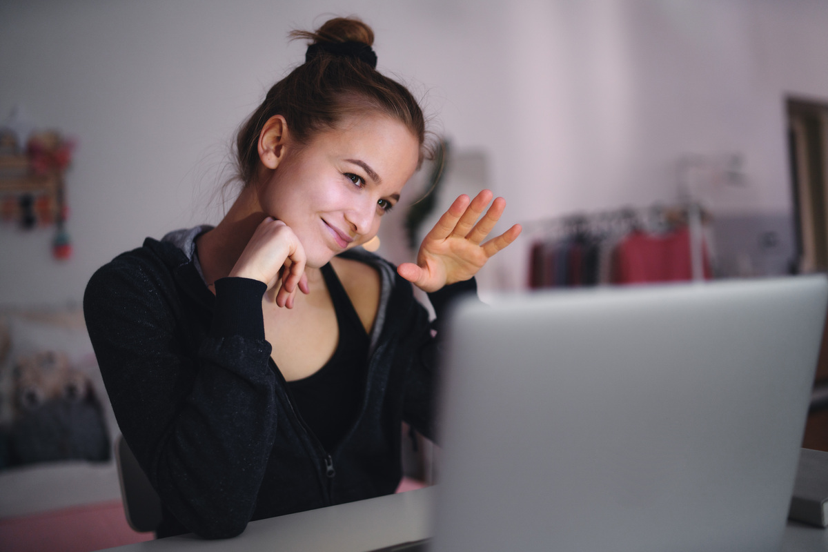 beautiful happy young girl with laptop sitting and smiling, online dating concept.