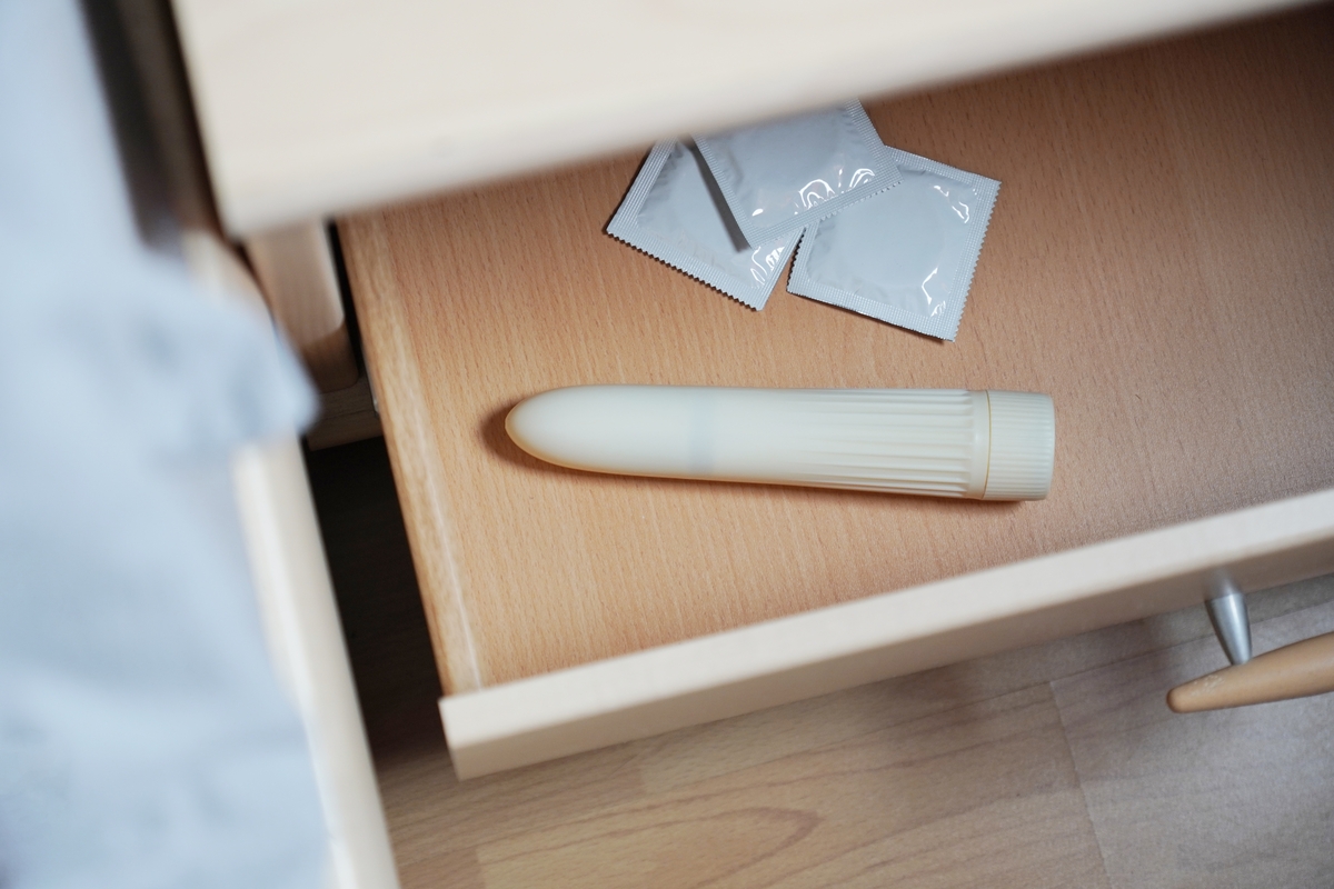 condoms and vibrator dildo in bedside table or nightstand drawer