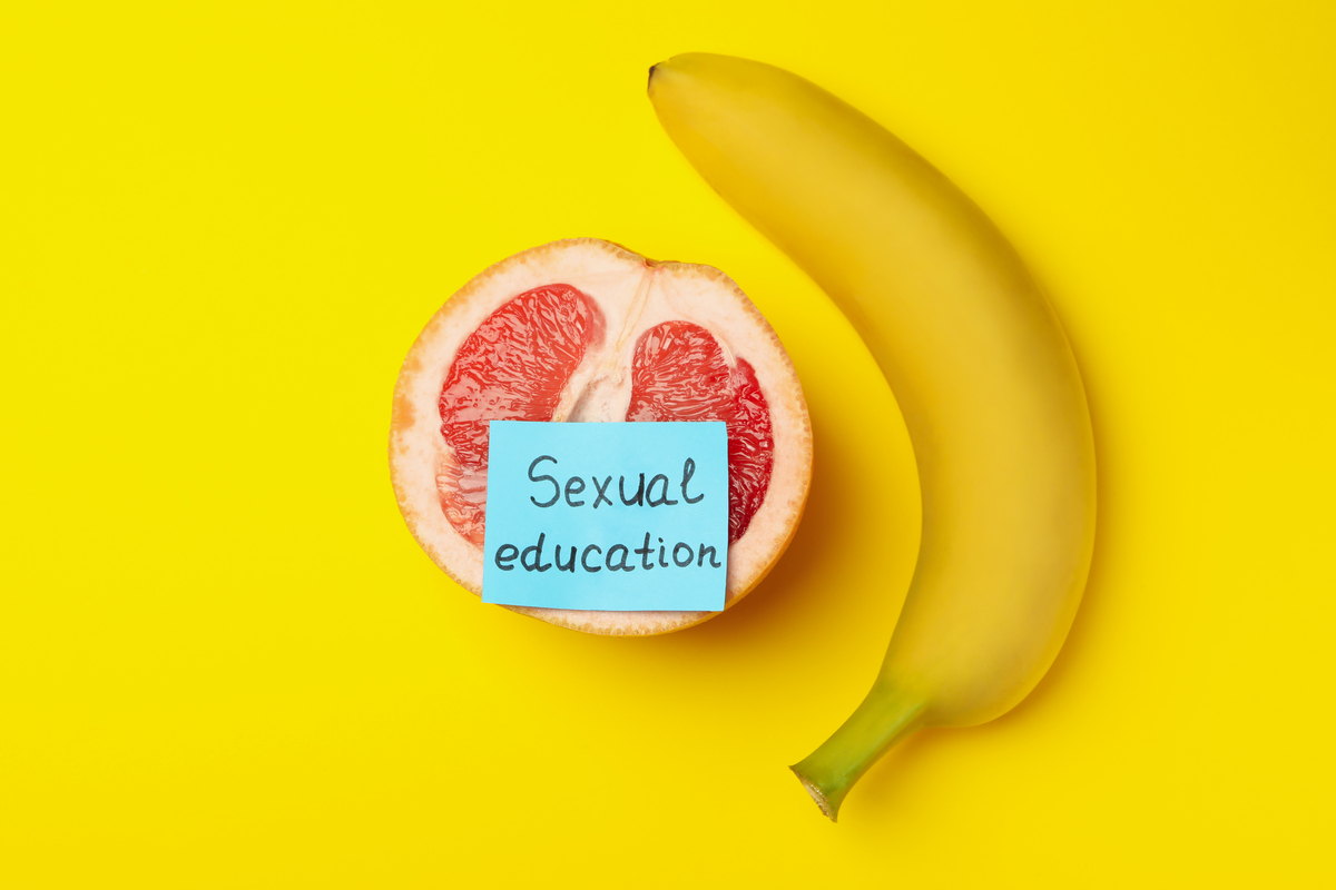 pomelo with text sexual education and banana on yellow backgroun