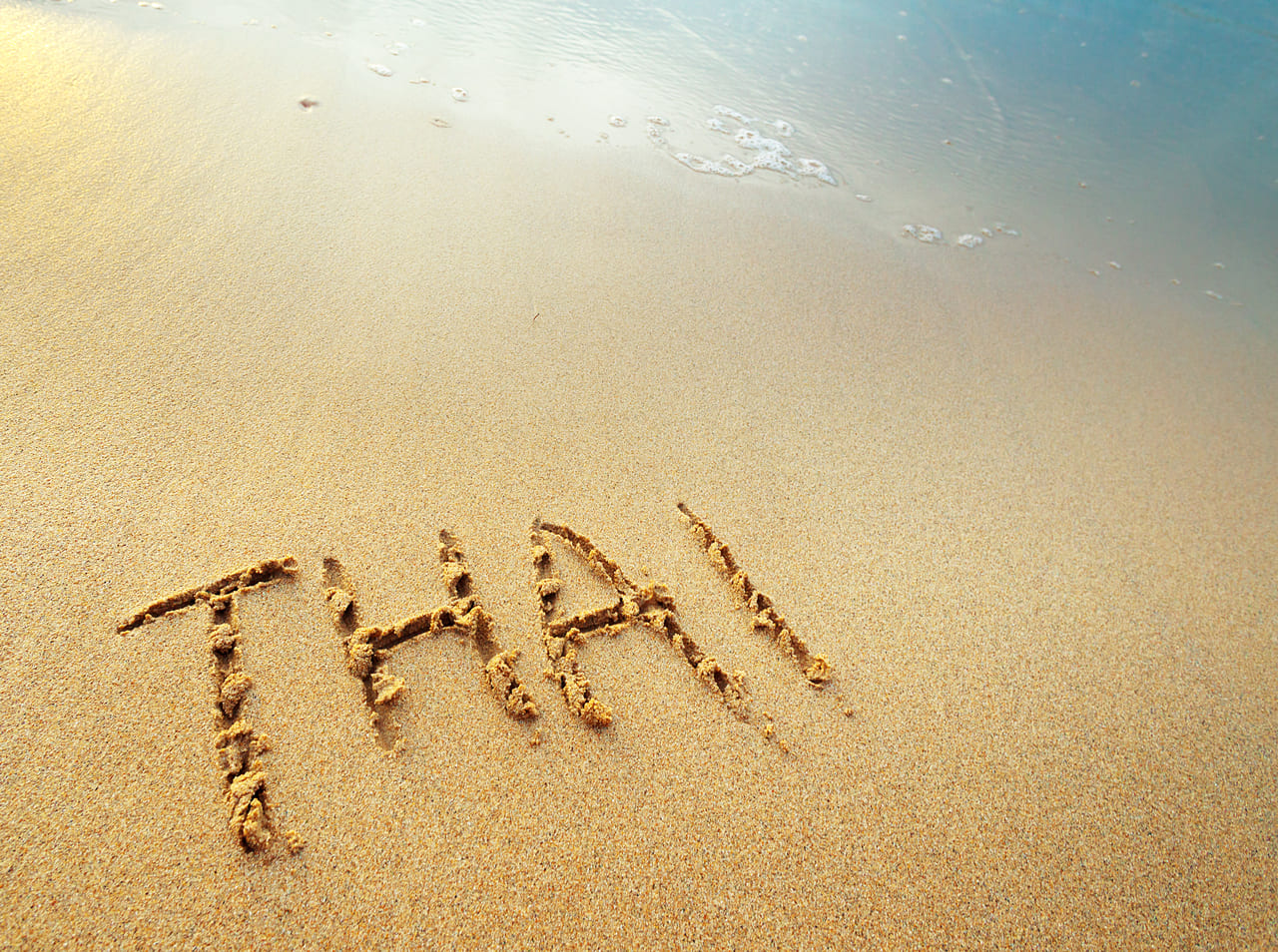 thai letters handwritten in sand on beach 2022 09 09 02 19 10 utc